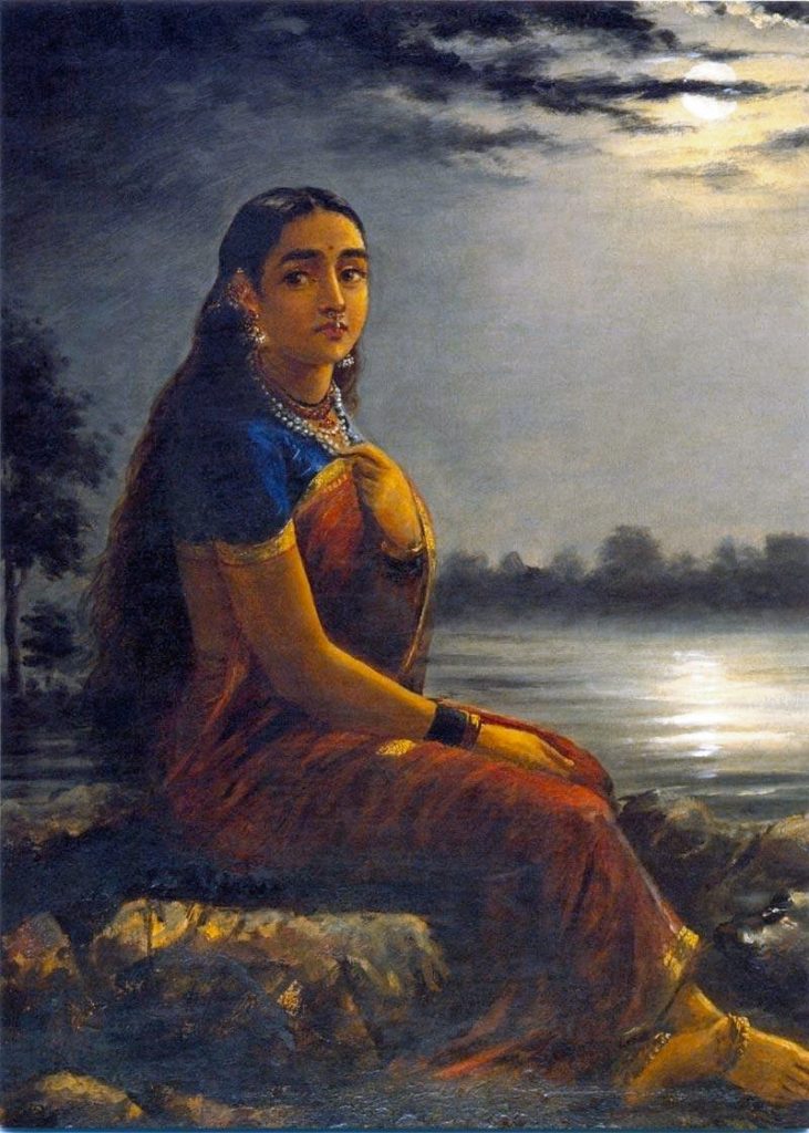 woman in a sari sitting by the water
