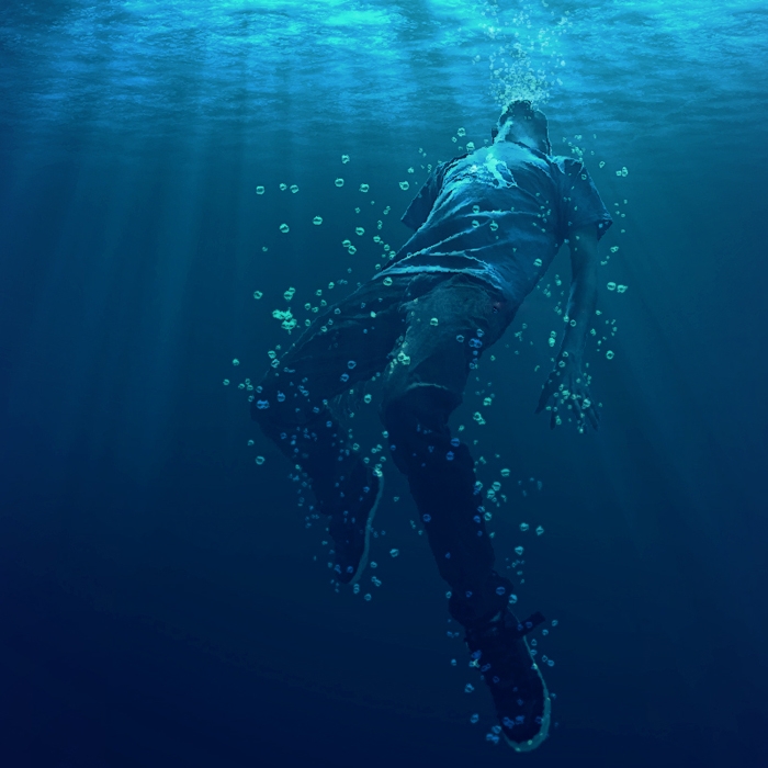 a man underwater, fully clothed