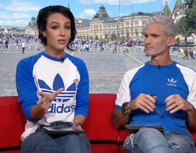 two people wearing adidas t-shirts speaking on television