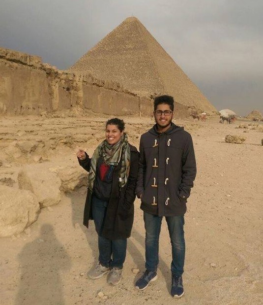 woman and slighter taller man standing in front of a pyramid in Egypt